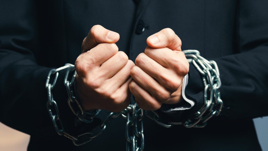 man dressed in jacket with chained hands
